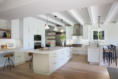 Design ideas for a large midcentury u-shaped open plan kitchen in San Francisco with an undermount sink, shaker cabinets, white cabinets, quartz benchtops, stainless steel appliances, medium hardwood floors, with island, brown floor and beige benchtop.