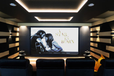 Idées déco pour une salle de cinéma contemporaine de taille moyenne avec un mur noir, moquette, un écran de projection et un sol gris.