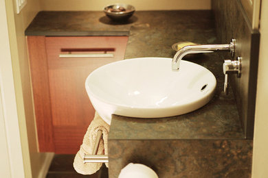 Mid-sized trendy porcelain tile and black floor bathroom photo in Vancouver with a vessel sink, flat-panel cabinets, medium tone wood cabinets and beige walls