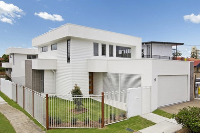 This is an example of a large contemporary two-storey concrete white house exterior in Gold Coast - Tweed with a flat roof and a metal roof.