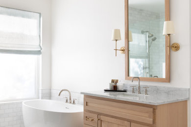 Example of a mid-sized trendy master white tile single-sink bathroom design in Austin with shaker cabinets, light wood cabinets, a one-piece toilet, white walls, an undermount sink, granite countertops, a hinged shower door and a built-in vanity