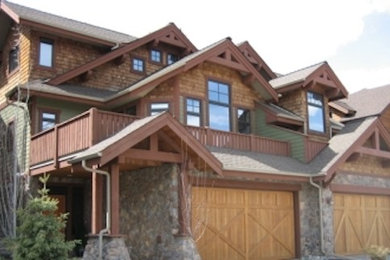 Large elegant brown three-story stone exterior home photo in Calgary