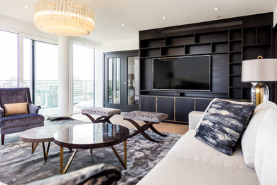 Large modern formal open plan living room in London with white walls, light hardwood flooring, no fireplace and a built-in media unit.