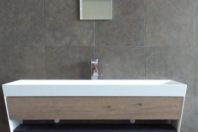 Idee per una stanza da bagno padronale design con ante con riquadro incassato, ante in legno chiaro, piastrelle marroni, piastrelle di marmo, pareti marroni, pavimento in marmo, lavabo integrato, top in superficie solida e pavimento grigio