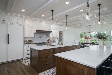 Example of a large transitional single-wall medium tone wood floor, brown floor and shiplap ceiling eat-in kitchen design in Other with a farmhouse sink, flat-panel cabinets, white cabinets, quartz countertops, white backsplash, porcelain backsplash, paneled appliances, two islands and white countertops