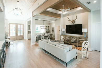 Living room - transitional light wood floor and beige floor living room idea in Houston with beige walls and a wall-mounted tv