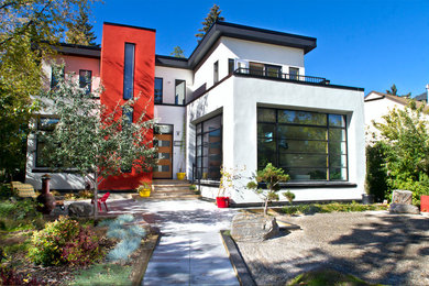 Mid-sized minimalist white two-story stucco flat roof photo in Calgary