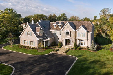 Large elegant beige two-story mixed siding gable roof photo in Chicago