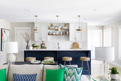 Open concept kitchen - transitional galley ceramic tile open concept kitchen idea in Minneapolis with an undermount sink, shaker cabinets, white backsplash, stainless steel appliances, an island, white countertops, quartz countertops, white cabinets and subway tile backsplash