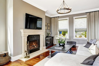 Inspiration for a mid-sized contemporary enclosed dark wood floor and brown floor family room remodel in DC Metro with beige walls, a standard fireplace, a stone fireplace and a wall-mounted tv