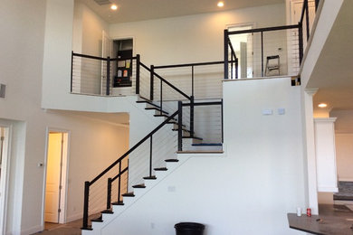 Photo of a modern wood staircase in Orlando with wood risers and metal railing.