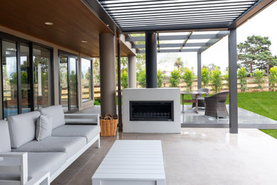 Design ideas for a mid-sized modern backyard patio in Auckland with tile and a roof extension.