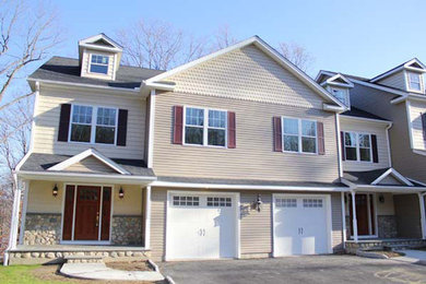 Example of a beige two-story exterior home design in New York