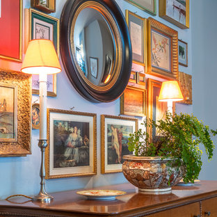Idée de décoration pour une entrée bohème de taille moyenne avec un vestiaire, un mur gris, un sol en bois peint, une porte double et une porte blanche.