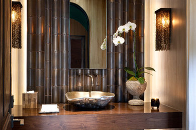 Design ideas for a tropical powder room in Los Angeles with a vessel sink, wood benchtops and brown benchtops.