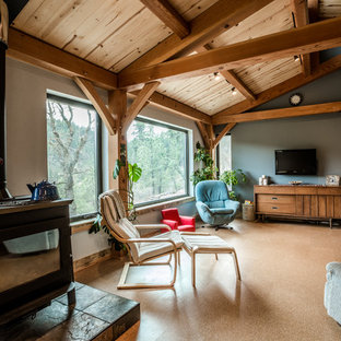 Idéer för mellanstora funkis allrum med öppen planlösning, med grå väggar, korkgolv, en öppen vedspis och en väggmonterad TV