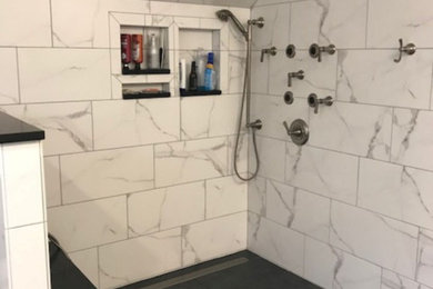 Ejemplo de cuarto de baño principal moderno grande con ducha abierta, suelo de baldosas de porcelana, suelo negro, ducha abierta y banco de ducha