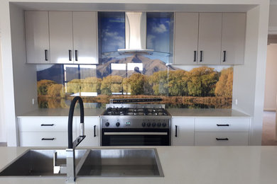 This is an example of a modern kitchen in Other with a double-bowl sink, glass sheet splashback, stainless steel appliances and with island.