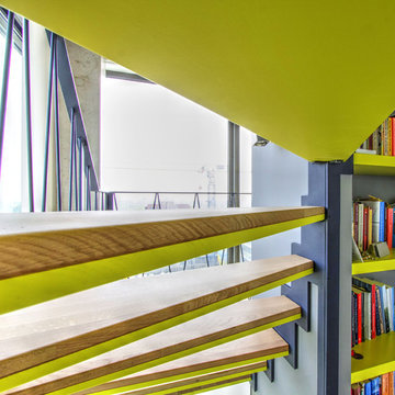 Moderne, halbgewendelte Podesttreppe mit Stahlwangen & integriertem Bücherregal