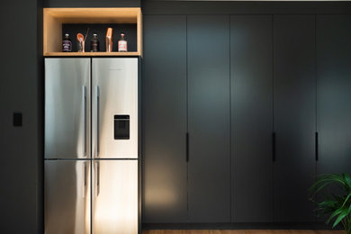Design ideas for a small contemporary u-shaped kitchen pantry in Melbourne with a drop-in sink, flat-panel cabinets, white cabinets, solid surface benchtops, white splashback, subway tile splashback, stainless steel appliances, no island and grey benchtop.
