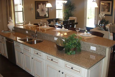 Kitchen - mid-sized kitchen idea in Phoenix with a double-bowl sink, recessed-panel cabinets, white cabinets, granite countertops, beige backsplash, stone slab backsplash, stainless steel appliances and an island