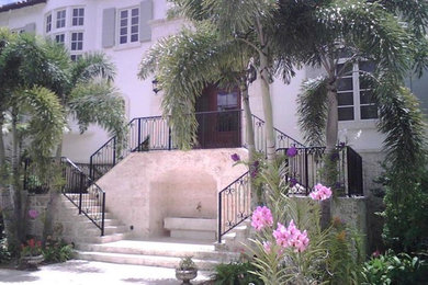 Example of a large island style white two-story mixed siding house exterior design in Miami with a hip roof and a tile roof