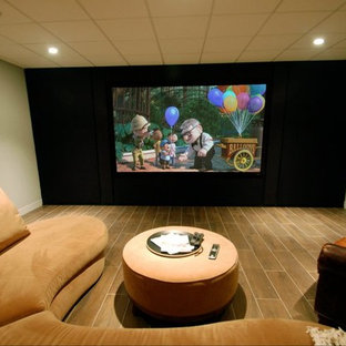 Inspiration pour une salle de cinéma traditionnelle de taille moyenne et fermée avec un mur vert, un sol en carrelage de porcelaine, un téléviseur encastré et un sol marron.