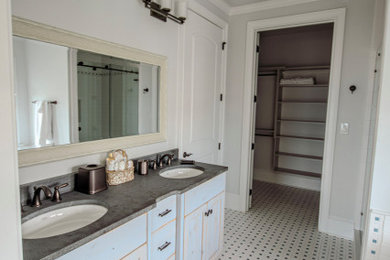 Example of a mid-sized beach style master white tile white floor, double-sink and vaulted ceiling bathroom design in Other with shaker cabinets, blue cabinets, white walls, an undermount sink, a hinged shower door, gray countertops and a built-in vanity