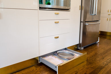 Example of a mid-sized trendy medium tone wood floor eat-in kitchen design in Seattle with an undermount sink, flat-panel cabinets, white cabinets, quartzite countertops, white backsplash, ceramic backsplash, stainless steel appliances and a peninsula