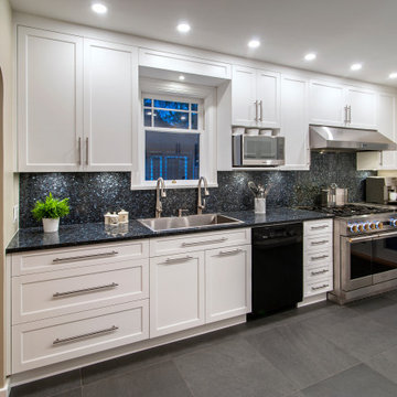 Functional & Stylish White Kitchen with Dark Countertops and Backsplash