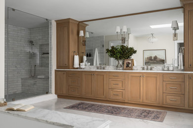 Example of a large transitional master white tile and marble tile marble floor, white floor and double-sink bathroom design in DC Metro with beaded inset cabinets, medium tone wood cabinets, an undermount tub, a one-piece toilet, white walls, an undermount sink, marble countertops, a hinged shower door, white countertops and a built-in vanity