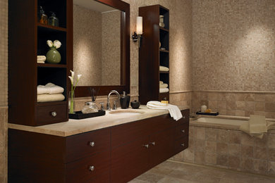 This is an example of a medium sized contemporary ensuite bathroom in Houston with flat-panel cabinets, dark wood cabinets, an alcove bath, beige tiles, stone tiles, beige walls, limestone flooring, a submerged sink and granite worktops.