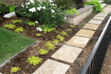 Arts and crafts front yard garden in Denver with natural stone pavers.