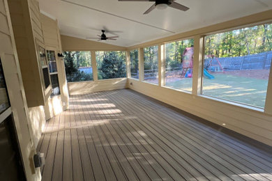 Screened-in back porch photo in Atlanta with a roof extension and decking