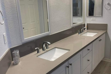 Mid-sized minimalist laminate floor, beige floor and double-sink bathroom photo in Boise with white cabinets, white walls, an undermount sink, quartzite countertops, gray countertops and a built-in vanity