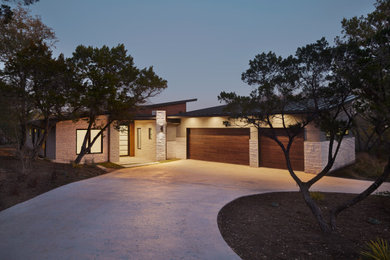 This is an example of a large contemporary one-storey grey house exterior in Austin with mixed siding, a shed roof and a metal roof.