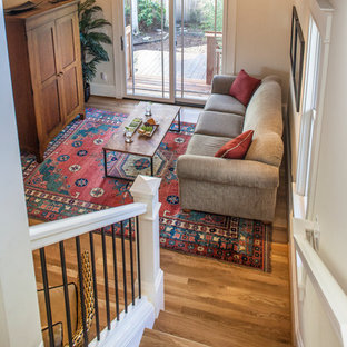 Ispirazione per un piccolo soggiorno stile americano aperto con pareti bianche, pavimento in legno massello medio, TV nascosta e nessun camino