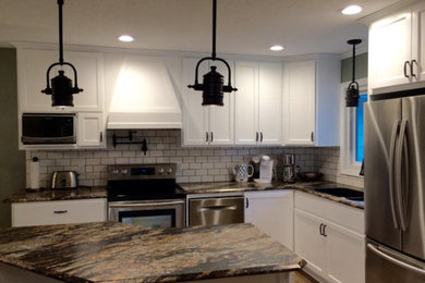 Mid-sized elegant l-shaped medium tone wood floor and brown floor eat-in kitchen photo in Other with a double-bowl sink, recessed-panel cabinets, white cabinets, granite countertops, white backsplash, subway tile backsplash, stainless steel appliances, an island and multicolored countertops