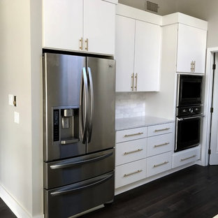 Idéer för att renovera ett mellanstort funkis kök, med en rustik diskho, släta luckor, vita skåp, bänkskiva i kvarts, grått stänkskydd, stänkskydd i marmor, rostfria vitvaror, mörkt trägolv, en köksö och svart golv