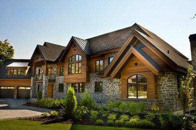 Large traditional brown mixed siding gable roof idea in Montreal