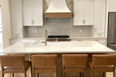 Open concept kitchen - small transitional galley light wood floor and vaulted ceiling open concept kitchen idea in Toronto with an undermount sink, recessed-panel cabinets, white cabinets, quartz countertops, quartz backsplash and stainless steel appliances