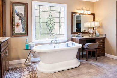 Inspiration for a mid-sized traditional master bathroom in Atlanta with raised-panel cabinets, dark wood cabinets, a freestanding tub, brown walls, medium hardwood floors, granite benchtops and brown floor.