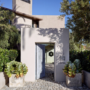 Idee per una porta d'ingresso mediterranea con pareti beige, una porta singola, pavimento in granito e una porta in metallo