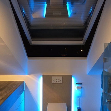 Toilette in kleinem Badezimmer mit Leuchte in Wand