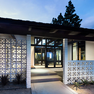 オレンジカウンティの大きい両開きドアミッドセンチュリースタイルのおしゃれな玄関ロビー (白い壁、淡色無垢フローリング、黒いドア、ベージュの床) の写真