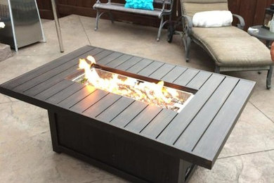 Patio - large contemporary backyard stamped concrete patio idea in Toronto with a fire pit and no cover