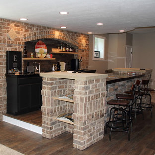 他の地域の中サイズのラスティックスタイルのおしゃれなウェットバー (アンダーカウンターシンク、落し込みパネル扉のキャビネット、黒いキャビネット、ライムストーンカウンター、茶色いキッチンパネル、石タイルのキッチンパネル、セラミックタイルの床) の写真