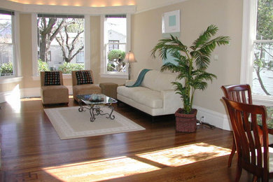 Large open concept medium tone wood floor living room photo in San Francisco with beige walls