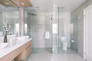 Example of a minimalist master double-sink bathroom design in Toronto with light wood cabinets and a hinged shower door