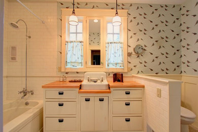 Bathroom - mid-sized coastal master white tile and subway tile mosaic tile floor and white floor bathroom idea in Other with flat-panel cabinets, white cabinets, a two-piece toilet, a vessel sink and wood countertops